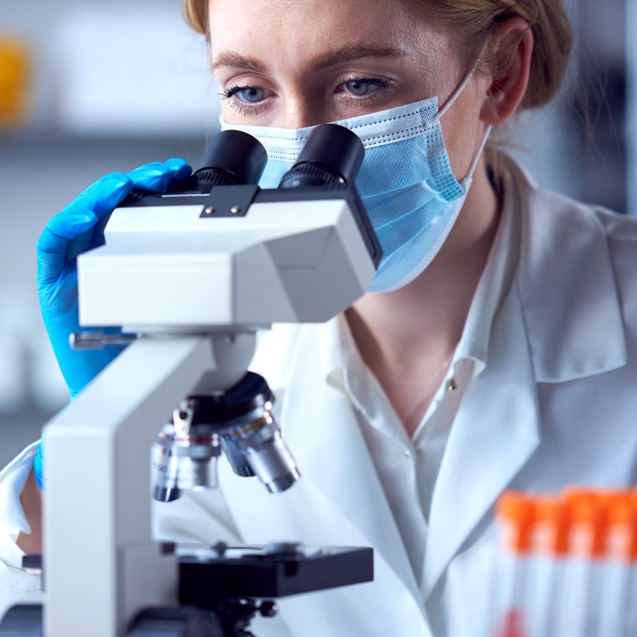 A scientist reviewing samples under a microscope